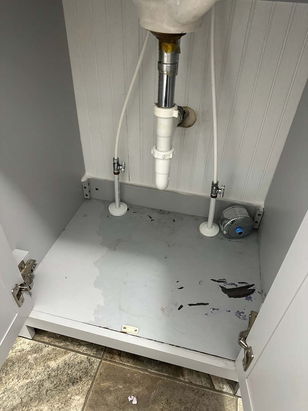 A leaking pipe in a bathroom vanity